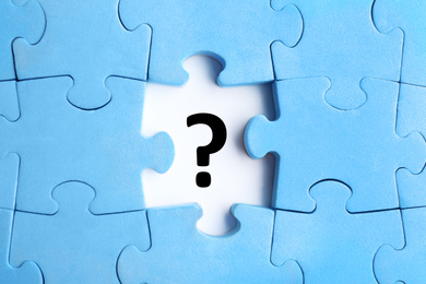 Image of Light blue puzzle with missing piece and question mark on white background, top view