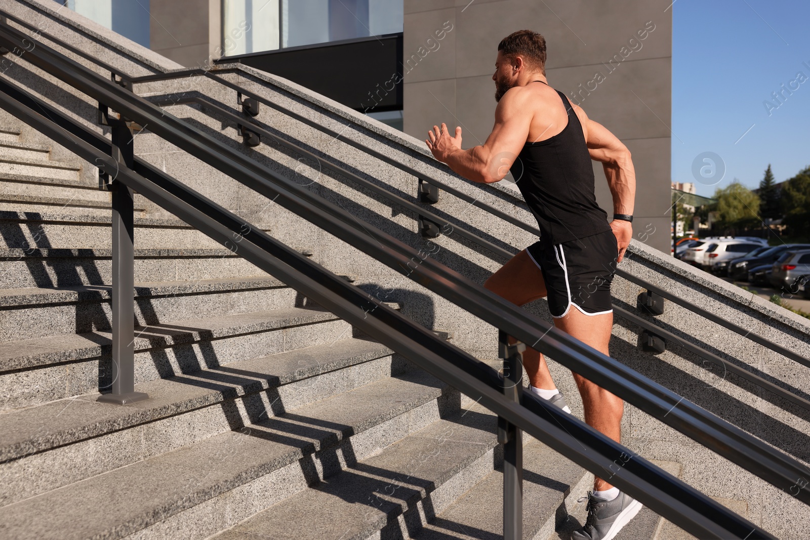 Photo of Man running up stairs outdoors on sunny day