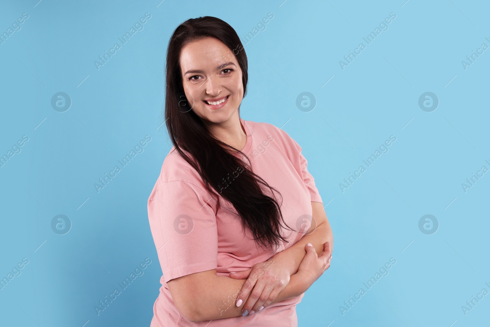 Photo of Beautiful overweight woman with charming smile on turquoise background