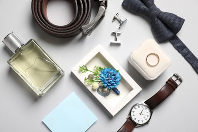 Photo of Wedding stuff. Flat lay composition with stylish boutonniere on light gray background