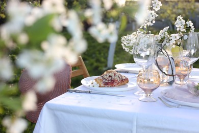 Stylish table setting with beautiful spring flowers in garden