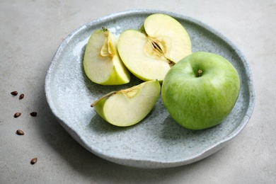 Plate with fresh green apples on table