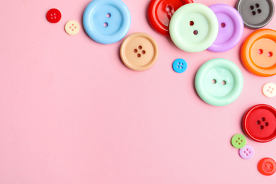 Many sewing buttons on pink background, flat lay. Space for text