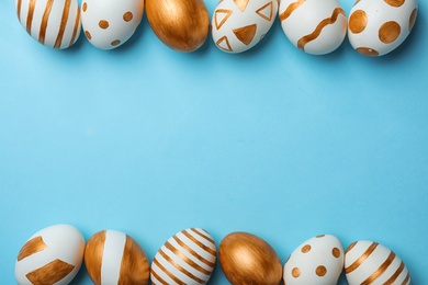Photo of Set of traditional Easter eggs decorated with golden paint on color background, top view. Space for text