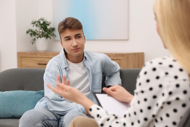 Psychologist working with teenage boy in office