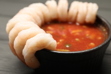 Photo of Tasty shrimp cocktail with sauce on grey wooden table, closeup
