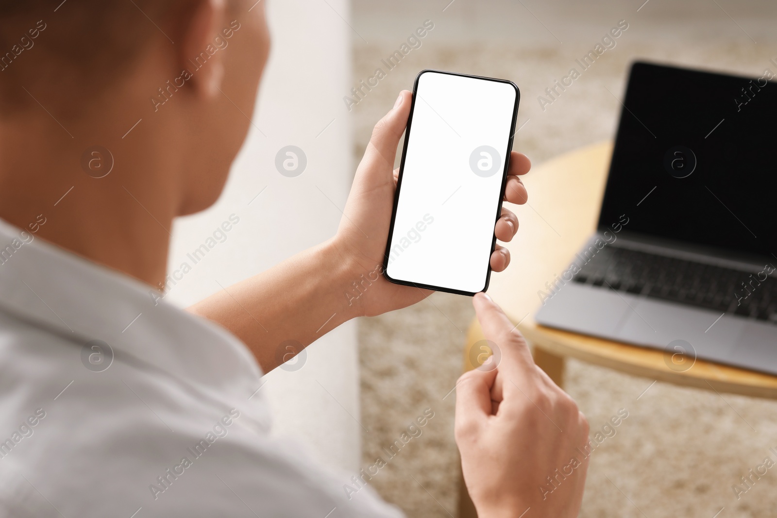 Photo of Man using smartphone with blank screen indoors, closeup. Mockup for design