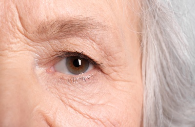 Wrinkled face of elderly woman, closeup of eye