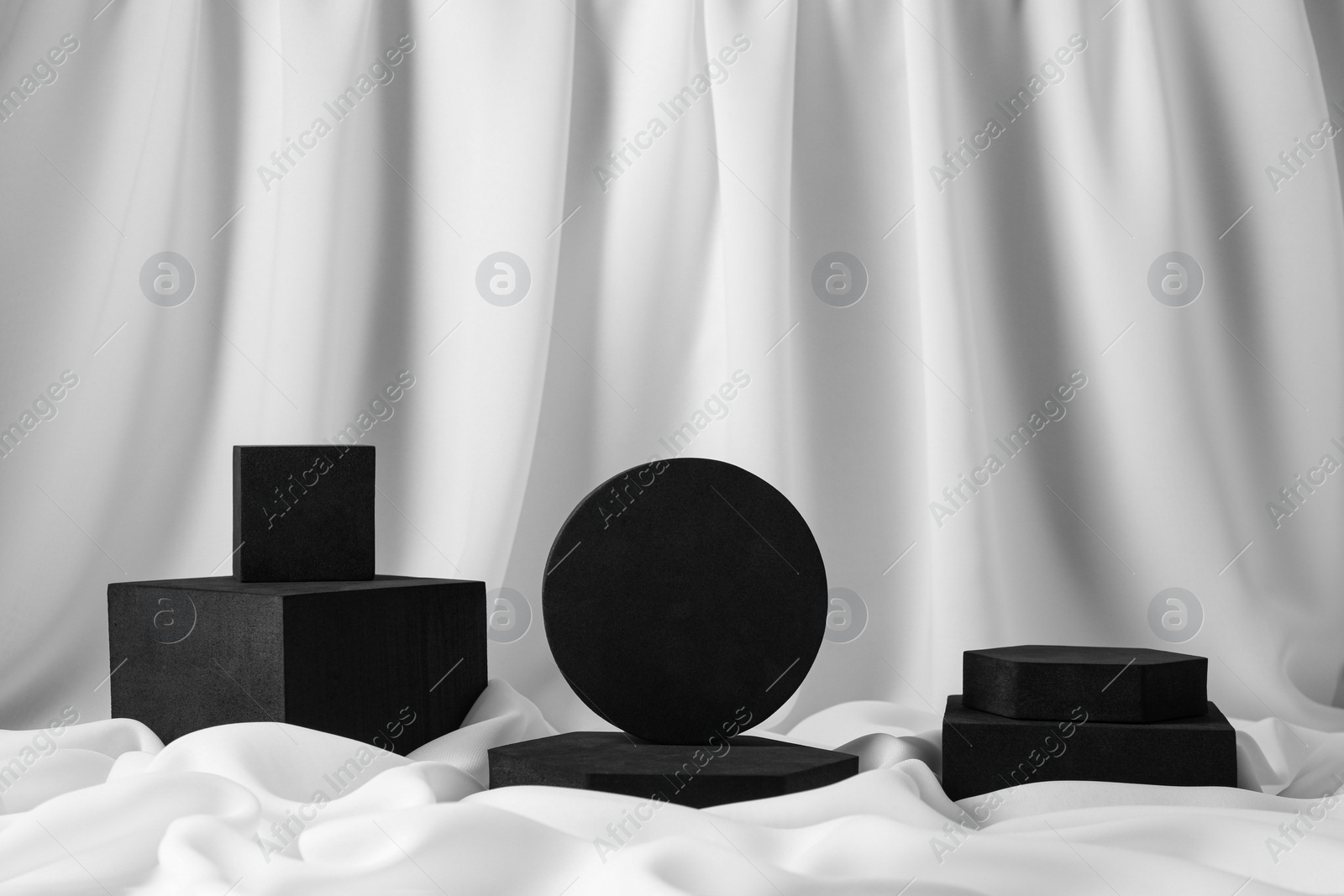 Photo of Black geometric figures on white fabric. Stylish presentation for product