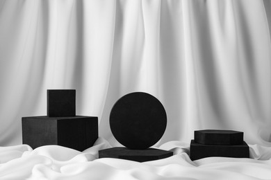 Photo of Black geometric figures on white fabric. Stylish presentation for product