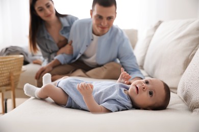 Photo of Happy family with cute baby on sofa at home