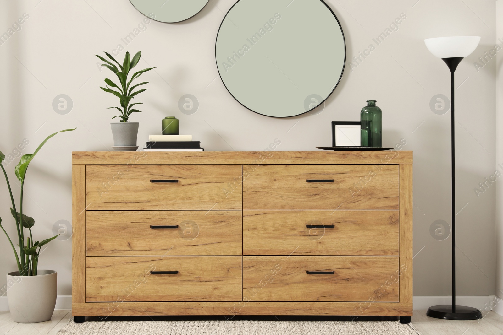 Photo of Cozy room interior with chest of drawers, mirrors and decor elements