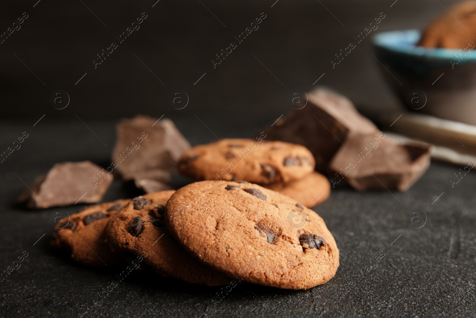 Photo of Tasty chocolate chip cookies on dark table