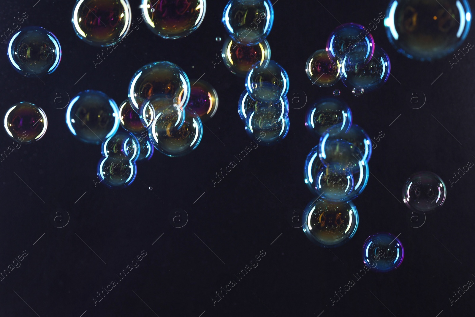 Photo of Beautiful transparent soap bubbles on dark background
