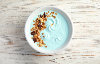 Photo of Bowl of spirulina smoothie on wooden background, top view