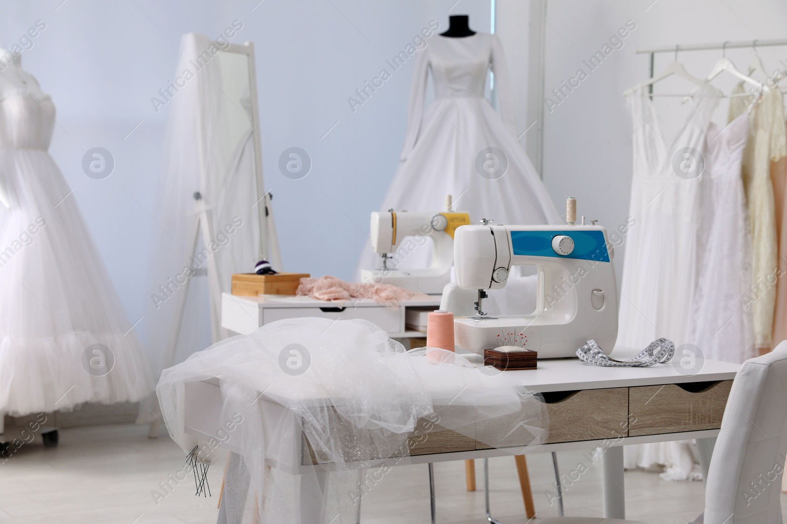 Photo of Dressmaking workshop interior with wedding dresses and equipment