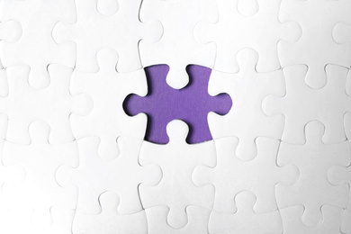 Photo of Blank white puzzle with missing piece on purple background, top view