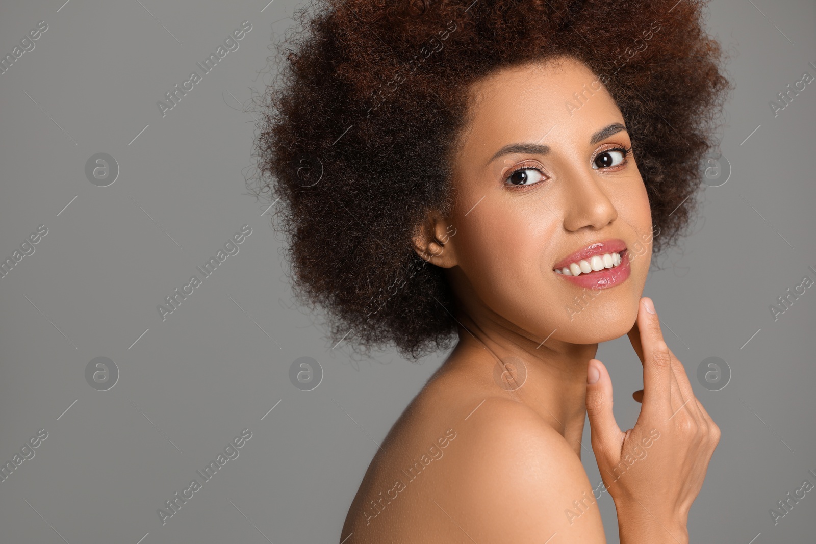 Photo of Portrait of beautiful young woman with glamorous makeup on grey background. Space for text