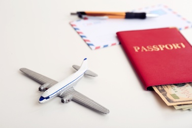 Photo of Composition with toy plane, passport and money on white background. Travel insurance