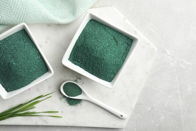 Photo of Flat lay composition with bowls of spirulina and space for text on light table