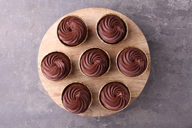 Photo of Delicious chocolate cupcakes on grey textured table, top view