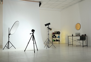 Photo studio interior with set of professional equipment and workplace