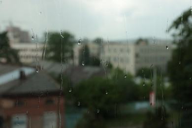 Photo of Window glass with droplets on rainy day, closeup