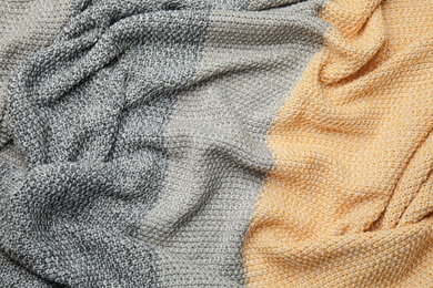 Soft crumpled knitted plaid as background, top view