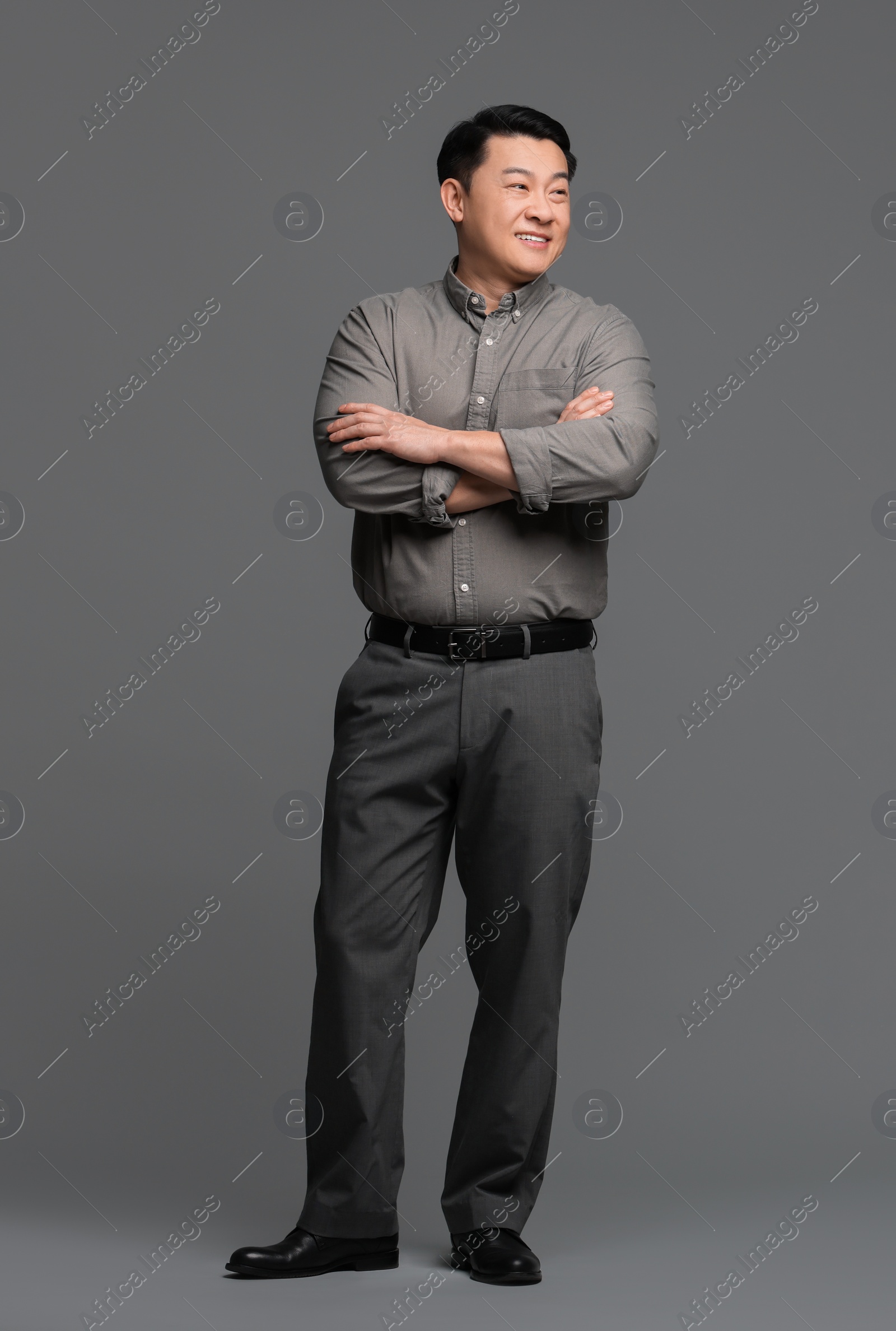 Photo of Full length portrait of happy businessman on grey background. Space for text