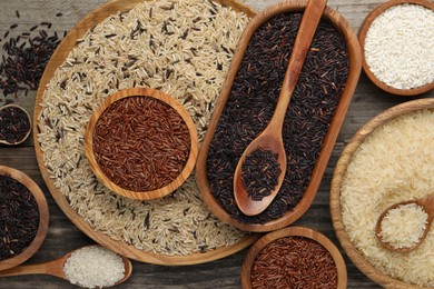 Different sorts of rice on wooden table, flat lay