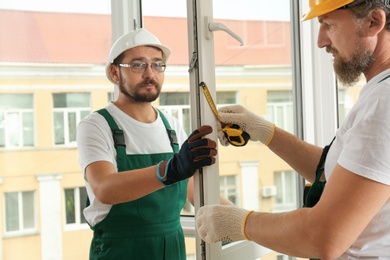 Construction workers installing new window in house