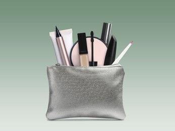 Image of Cosmetic bag filled with makeup products on color gradient background