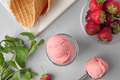 Photo of Flat lay composition with pink ice cream, mint and strawberries on grey table