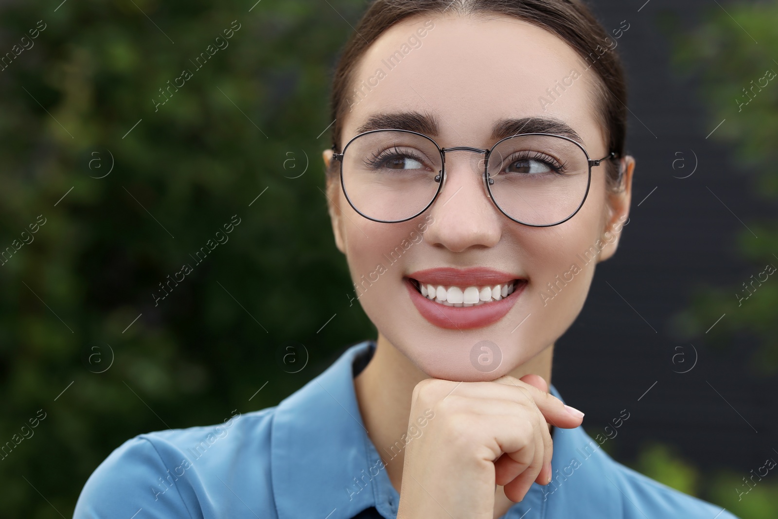 Photo of Portrait of beautiful woman in glasses on blurred background. Attractive lady smiling and posing for camera