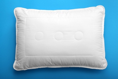 Soft bed pillow on color background, top view