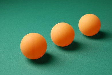 Photo of Three ping pong balls on green background