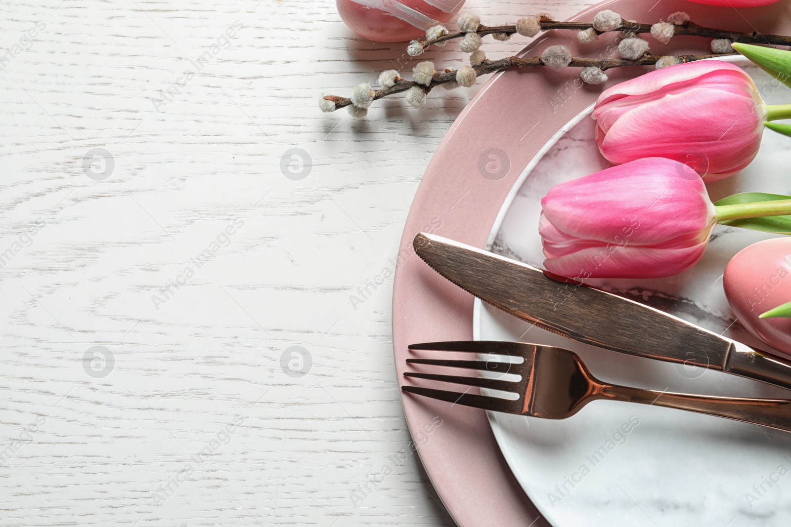 Photo of Festive Easter table setting with flowers on wooden background, above view. Space for text