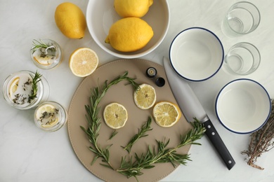 Flat lay composition with natural homemade mosquito repellent candles and ingredients on white table