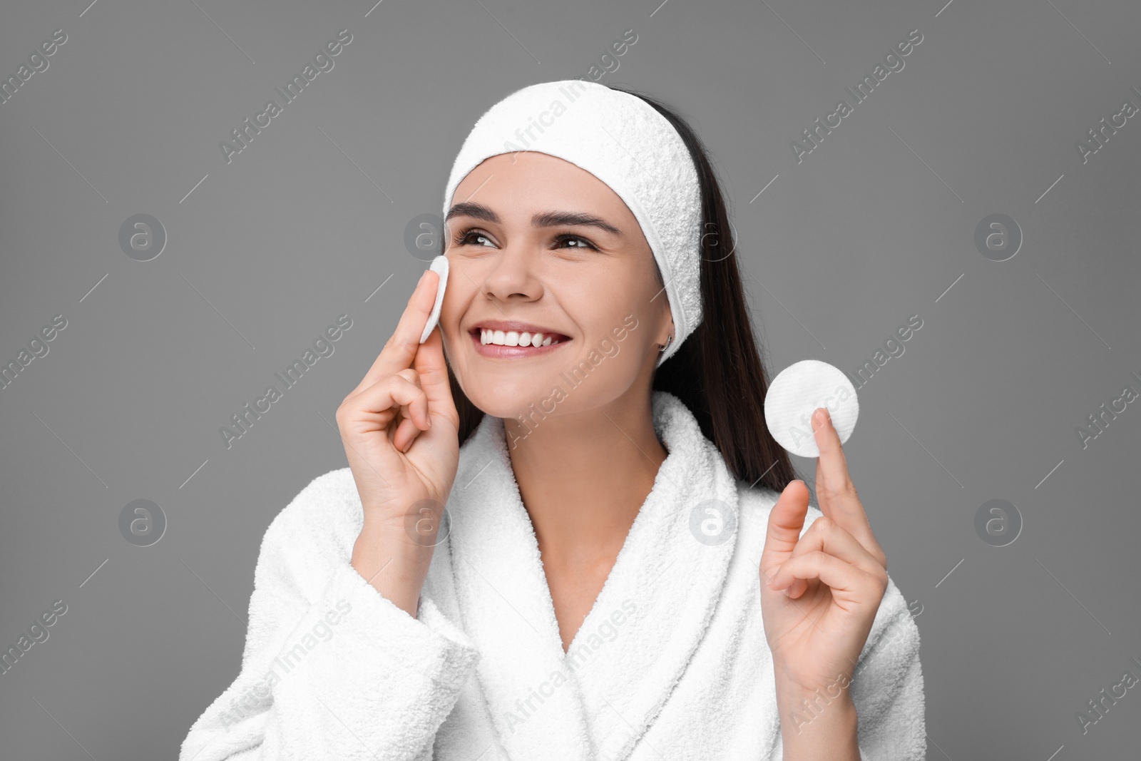Photo of Young woman with cotton pads on grey background