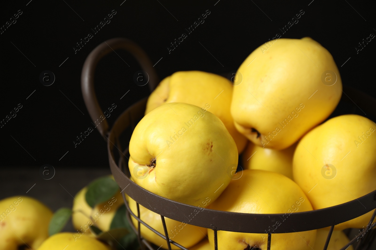 Photo of Fresh ripe organic quinces in metal basket, closeup