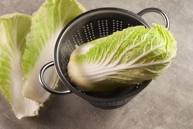 Photo of Fresh ripe Chinese cabbage and leaves on light grey table