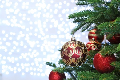 Photo of Christmas tree with festive decor against blurred fairy lights