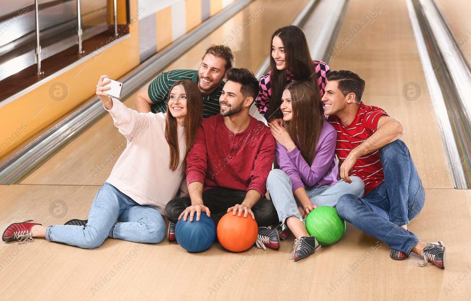 Photo of Group of friends taking selfie in bowling club