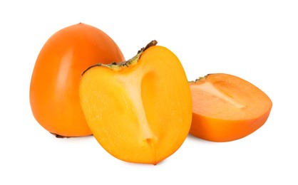 Whole and cut delicious ripe juicy persimmons on white background