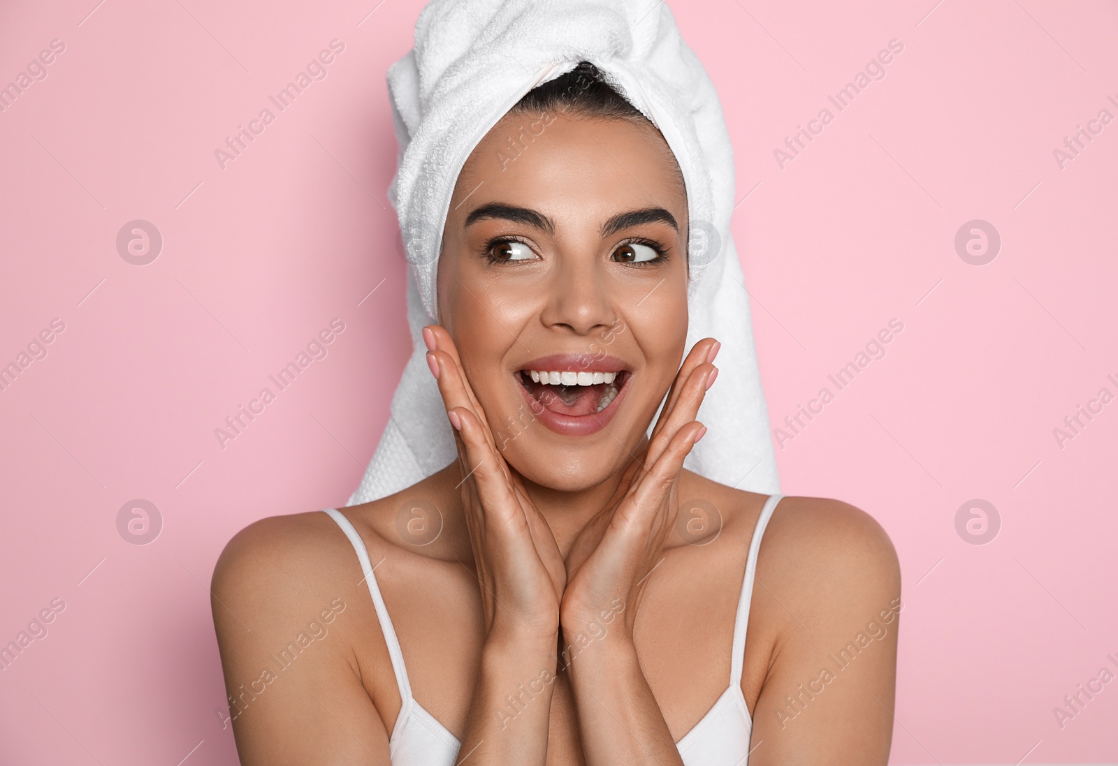 Photo of Beautiful young woman with towel on head against pink background