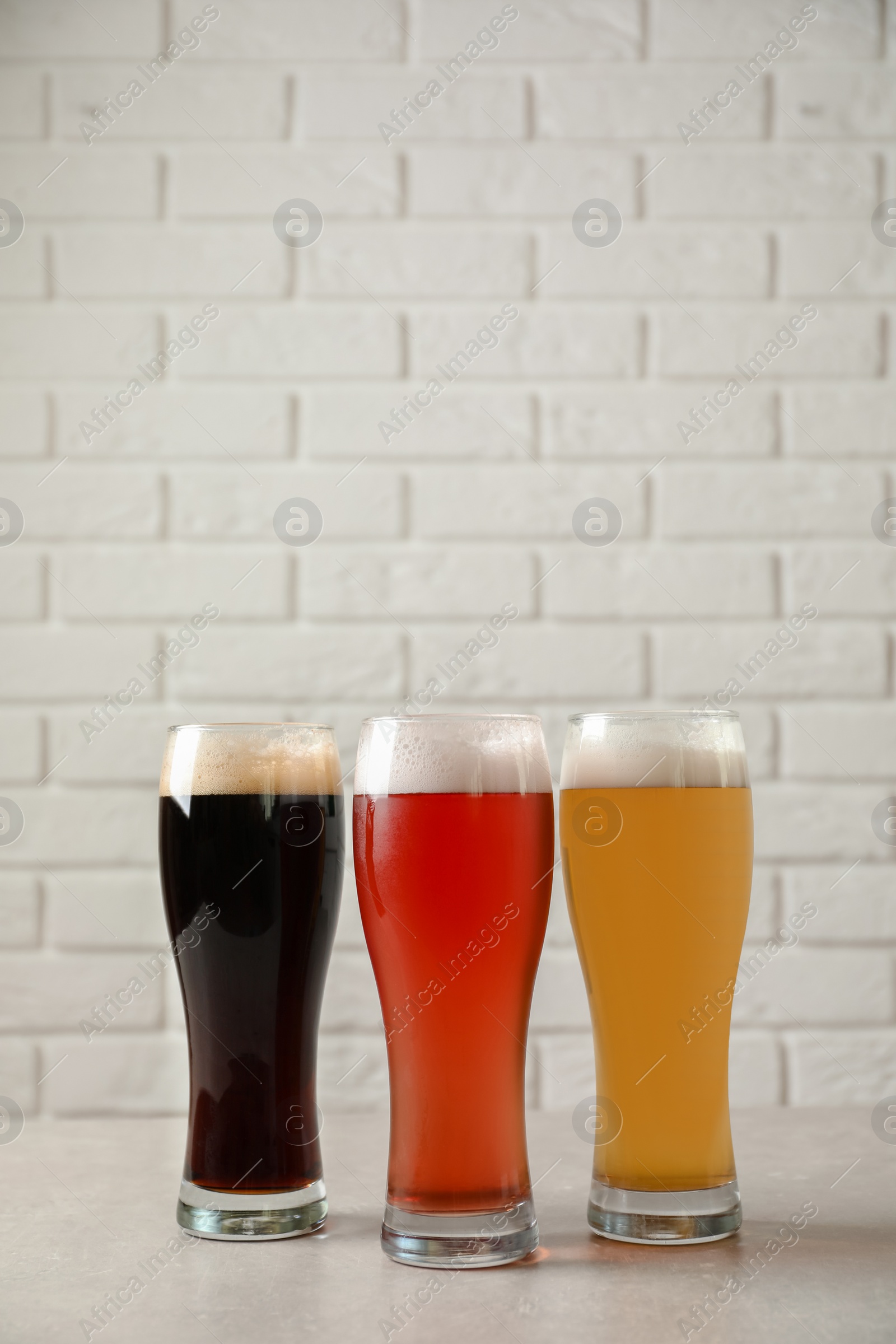 Photo of Glasses with different types of cold tasty beer on table