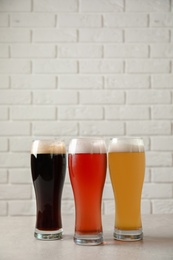 Photo of Glasses with different types of cold tasty beer on table