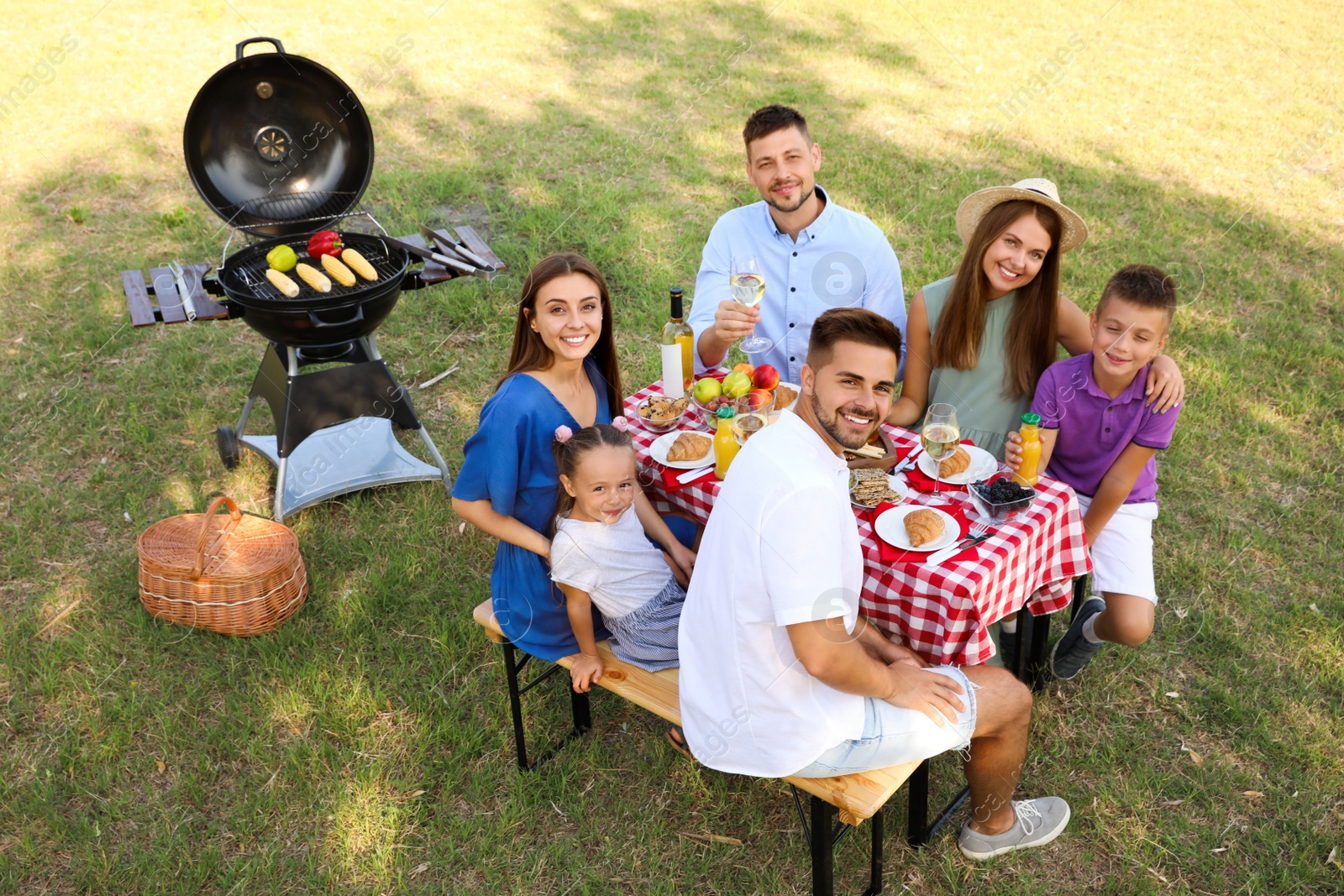 Photo of Happy families with little children having picnic in park