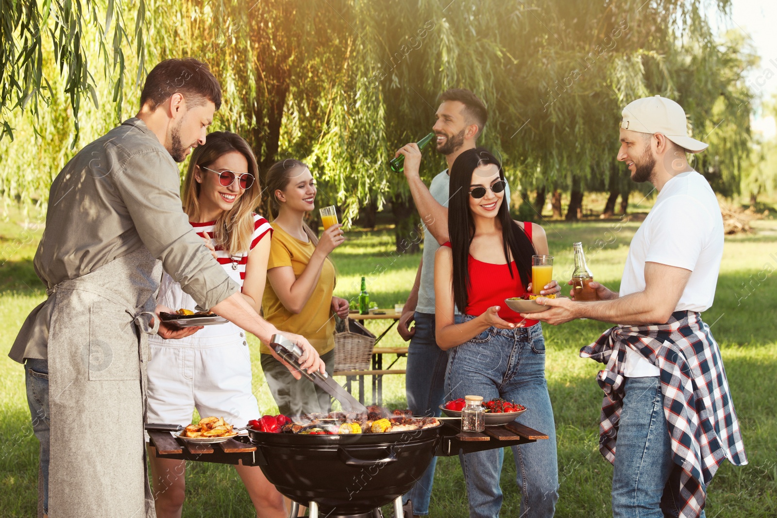 Photo of Group of friends having barbecue party in park