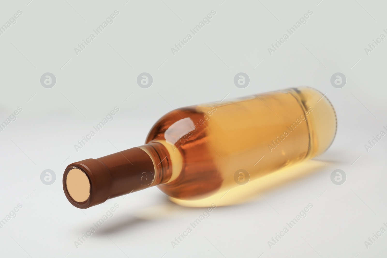 Photo of Bottle of expensive white wine on light background